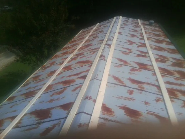 Rusted metal roof panels with new wood purlins before replacement — Storm Damage Roof Repair in Madrid by Roofing Brothers